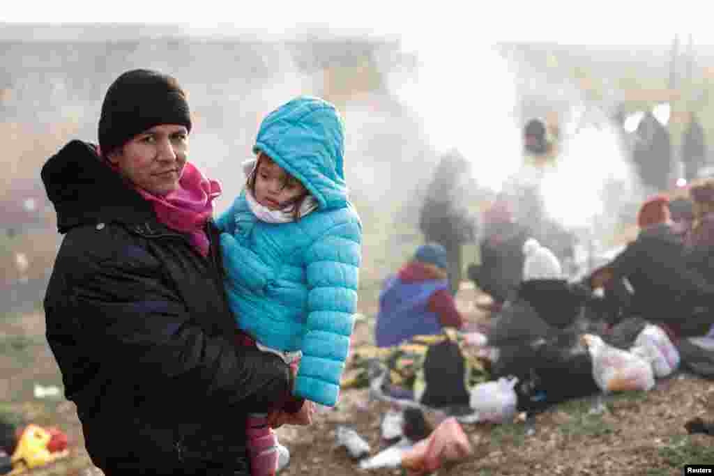 A migrant from Afghanistan holds his daughter as they wait on a roadside near Turkey&#39;s Ipsala border crossing with Greece. (Reuters/Murad Sezer)