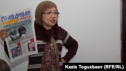 Розлана Таукина, редактор "Правдивой газеты", показывает в суде один из номеров издания. Алматы, 10 февраля 2014 года. 