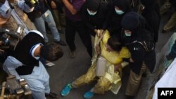 Pakistani policewomen arrest an activist of opposition party Tehreek-e Insaf (PTI) near the house its leader Imran Khan in Islamabad on October 31.