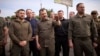 Ukrainian President Volodymyr Zelenskiy (left) thanked rescuers on June 8 as he visited a crossing point for those evacuated from flooded areas in the southern region of Kherson. 