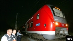 Police stand by a regional train in Germany where an Afghan man wielding an ax attacked passengers. 