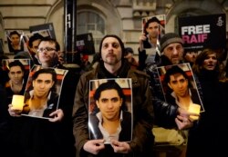 Протестная акция перед посольством Саудовской Аравии в Лондоне. Участники держат в руках портреты Раифа Бадави. 2015 год