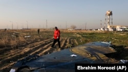 A rescue worker searches the scene where a Ukrainian plane crashed in Shahedshahr southwest of the capital Tehran, Iran, Wednesday, Jan. 8, 2020