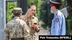 Көшеде кетіп бара жатқан азаматты тоқтатқан полиция қызметкерлері. Алматы, 25 сәуір 2020 жыл.
