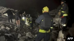 Ukrainian Emergency Service personnel work at the site of a Russian air strike in Dnipro, eastern Ukraine, early on October 26.