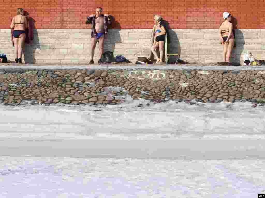 Elderly Russian men and women sunbathe near the wall of the Peter Paul fortress in St. Petersburg on March 16, 2009. Russians are enjoying some sunshine at the end of a long harsh winter. (AFP/Elena Palm) 