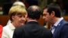 German Chancellor Angela Merkel (left), French President Francois Hollande (center), and Greek Prime Minister Alexis Tsipras confer during intense bailout negotiations in Brussels on July 12. 