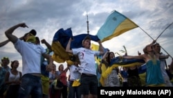 Молоді люди під час флешмобу на підтримку армії України неподалік міста Ізюм, що на Харківщині, 12 липня 2014 року