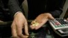 An Iranian goldsmith counts his gold coins at a gold market in the main old Bazaar of Tehran, Iran, Thursday, Jan. 26, 2012. Iranians, worried about the potential impact of the latest sanctions, in recent months appeared focused on buying up dollars and g