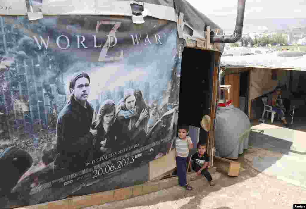 Syrian refugees rest beside a film poster being used as part of a tent in an informal settlement in Zahle in the Bekaa Valley, Lebanon. (Reuters/ Mohamed Azakir)