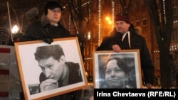 Участники акции антифашистов держат портреты адвоката Маркелова и журналиста Бабуровой. Москва, 19 января 2012 года.