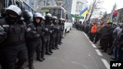 Riot police face pro-European protesters in front of the seat of Ukraine's Cabinet of Ministers in Kyiv on December 4.