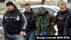 Macedonian police officers escort suspects facing trial in last year's assault on the parliament.