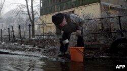 Чоловік набирає воду з пошкодженої труби, Донецьк, 15 лютого 2015 року