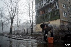 Місцевий житель набирає воду зі зруйнованого водопроводу. Донецьк, лютий 2015 року