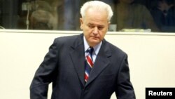 Former Yugoslav President Slobodan Milosevic enters a courtroom in The Hague in August 2004.