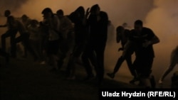 Людзі ратуюцца ад сьвятлашумавых гранат каля стэлы ў Менску ў ноч з 9 на 10 жніўня