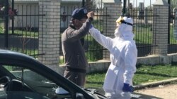 Тұрғынның дене қызуын тексеріп тұрған медицина қызметкері. Шымкент, 2 сәуір 2020 жыл.