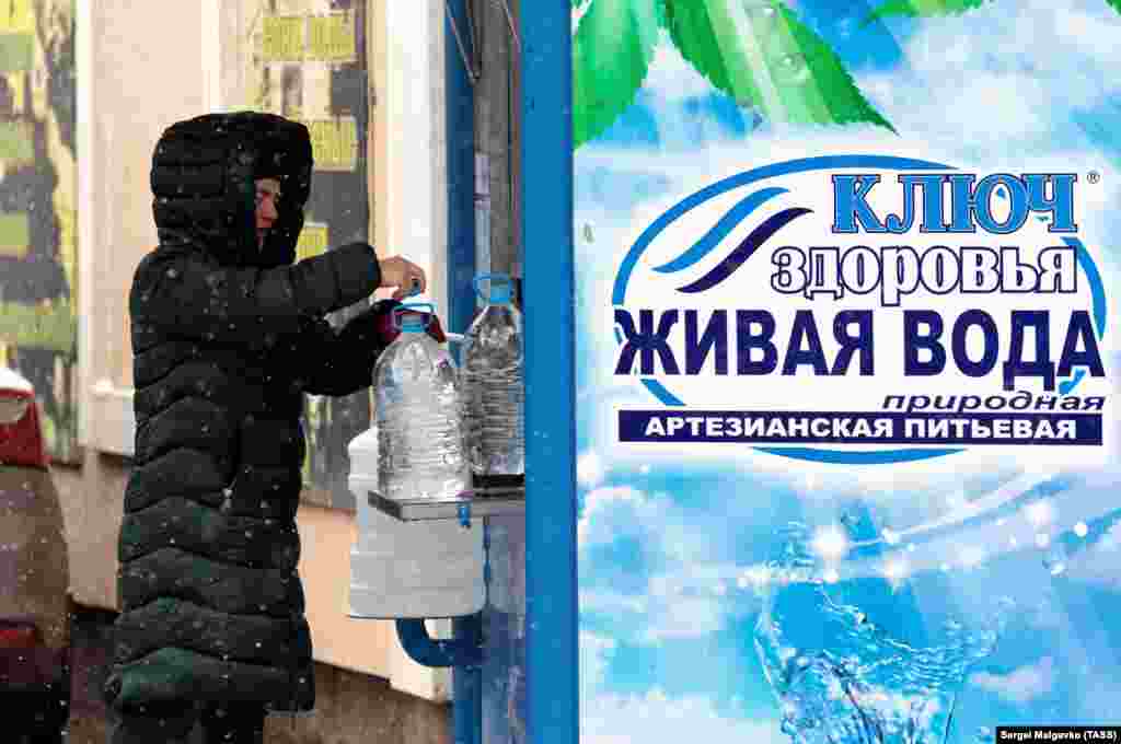 Покупательница у киоска по продаже воды в поселке Кирпичное в пригороде Симферополя
