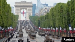 Armored vehicles drive down the Champs-Elysees during the Bastille Day parade in Paris on July 14, 2021.