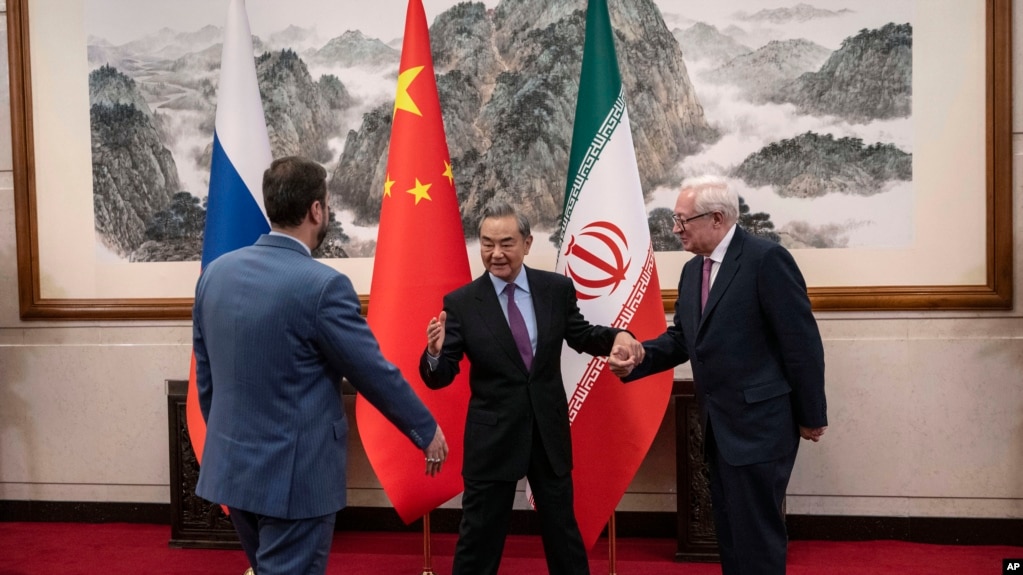 Chinese Foreign Minister Wang Yi welcomes Russian Deputy Foreign Minister Sergei Ryabkov (right) and Iranian Deputy Foreign Minister Kazem Gharibabadi (left) in Beijing, March 14