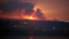 A view shows smoke and fire on the Lebanese side of the border with Israel, as seen from Tyre, southern Lebanon, early on August 25.