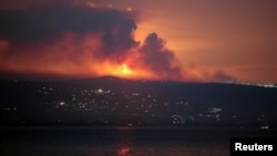 A view shows smoke and fire on the Lebanese side of the border with Israel, as seen from Tyre, southern Lebanon, early on August 25.