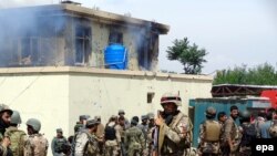Afghanistan -- Afghan security officials take up positions at the scene of an attack by Taliban militants targeting the justice office in Jalalabad city, provincial capital of Nangarhar Province, May 12, 2014