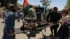 Afghan men carry a victim of a powerful car bomb in Lashkar Gah on June 22.