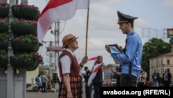Ніна Багінская і міліцыянт падчас акцыі «Праспэкт нацыянальнага сьцяга», архіўнае фота