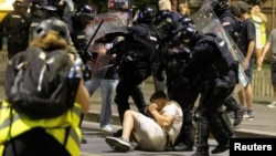 Srpski policajci privode demonstranta tokom obračuna između pristalica vladajuće stranke i antivladinih demonstranata u Beogradu, 13. avgusta 2025. godine.