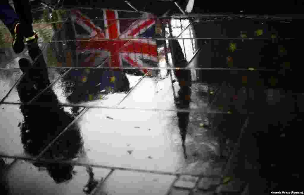 British and EU flags are reflected on a wet pavement in London. (Reuters/Hannah McKay)