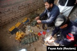 Police go through weapons collected from the bodies of attackers after the shooting in Peshawar on December 1.