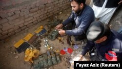 Police go through weapons collected from the bodies of attackers after the shooting at Directorate of Agriculture Institute in Peshawar on December 1.
