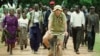 Zimbabwean commercial famer Tommy Bayley rides an old bicycle ahead of war veterans and villagers who invaded his farm Danbury Park 30 km's northwest of Harare to an abandoned house to use as temporary shelter April 8, 2000. Zimbabwe was thrown into turmoil in February when Mugabe's supporters and self-styled veterans of the 1970s war of liberation invaded white-owned farms, demanding land they said had been illegally taken away by colonisers. REUTERS
