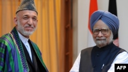 Indian Prime Minister Manmohan Singh (right) welcomes Afghan President Hamid Karzai to New Delhi on October 4.