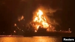 Кораб е осветен от пожар, избухнал на танкер с гориво в иракски води след атака, за която се смята, че е проведена от ирански плавателни съдове