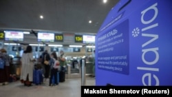 Пассажиры выстраиваются в очередь у стойки регистрации для регистрации на рейс авиакомпании Белавиа, направляющийся в Минск, в подмосковном аэропорту Домодедово, 28 мая 2021 г. 