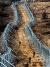 Soldiers patrol between a razor wire fence marking North Macedonia's border with EU member Greece. (file photo)