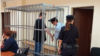 Andrei Lugovoi is placed in a defendant's cage in a court on Svetlogorsk on September 20. 