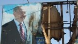 Жартылай жанып кеткен президент Нұрсұлтан Назарбаевтың бейнесі басылған банер. Жаңаөзен, 19 желтоқсан 2011 жыл