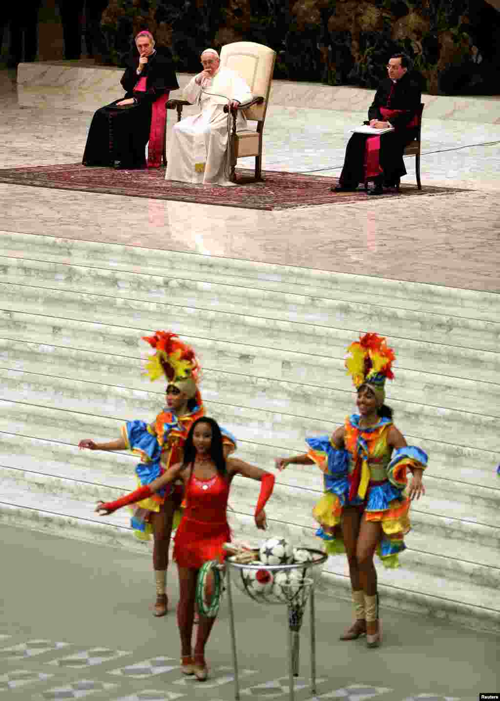 ВАТИКАН - Бразилски танчерки настапуваат пред папата Франциск, за време на главната аудиенција во катедралата Павле Шести, пред католичкиот Божиќ. Поглаварот на римокатоличката црква е во постојана служба по повод претстојните божиќни празници и секоја миса ја користи за да повика да престанат воените конфликти и насилство во светот.
