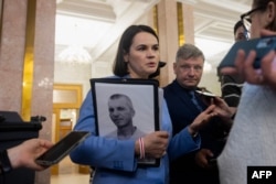 Сьвятлана Ціханоўская трымае ў руках тэчку з фотаздымкам беларускага палітычнага зьняволенага Алега Малчанава. Кіеў, 25 траўня