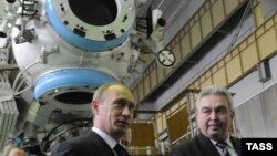 Russian then-Prime Minister Vladimir Putin (left) and Khrunichev Center chief Vladislav Nesterov confer at Khrunichev Space Center in March 2009.
