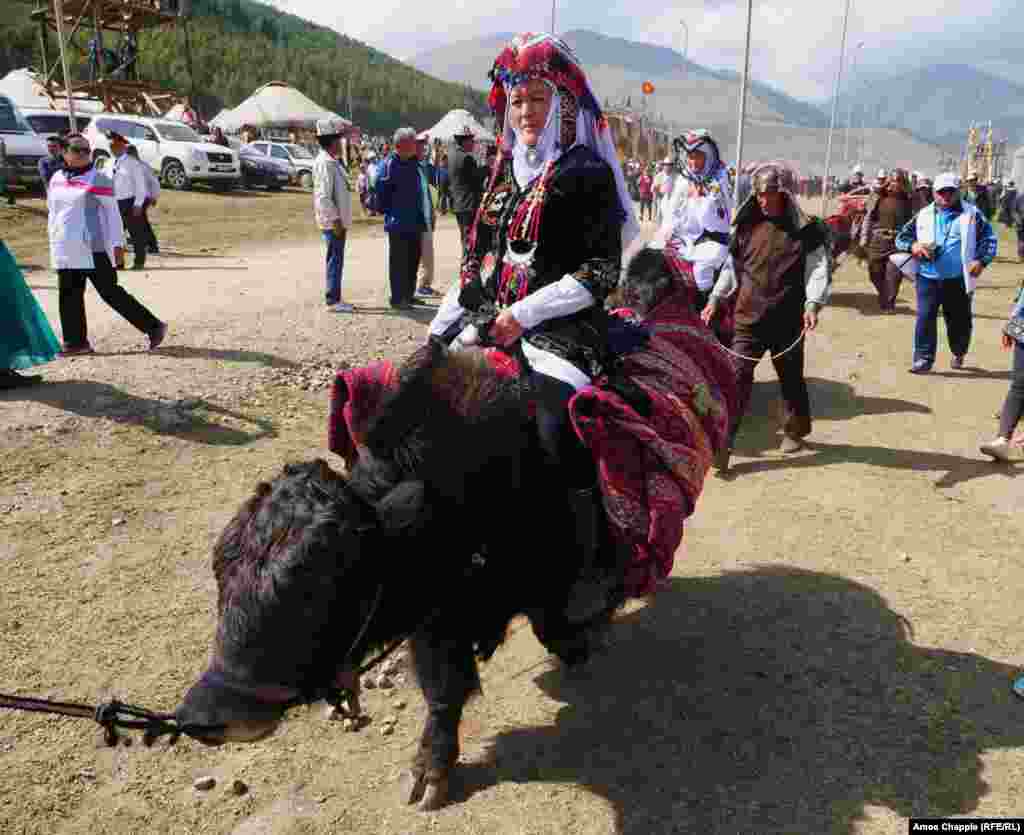 Elderly Kyrgyz women cruise through the crowds on yaks en route to the main stage.