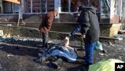 People try to identify a victim killed during shelling that Russian officials in Donetsk said was conducted by Ukrainian forces on January 21.