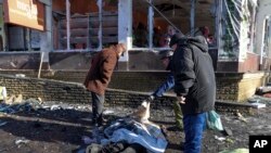 Oamenii încearcă să identifice o victimă ucisă în timpul bombardamentelor despre care oficialii ruși din Donețk au spus că au fost efectuate de forțele ucrainene pe 21 ianuarie.