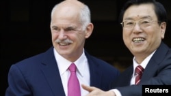 Greek Prime Minister George Papandreou (left) welcomes Chinese Vice Premier Zhang Dejiang to Athens on June 15.