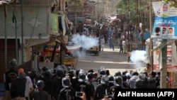 Pakistani policemen fire teargas shells towards protesters during a demonstration against the rape and murder of a six-year-old girl in Karachi on April 17.