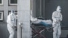 Мэдыцынскія работнікі дастаўляюць пацыента ў бальніцу, дзе праходзяць лекаваньне пацыенты, інфікаваныя новым вірусам. Ухань, 18 студзеня 2020 году